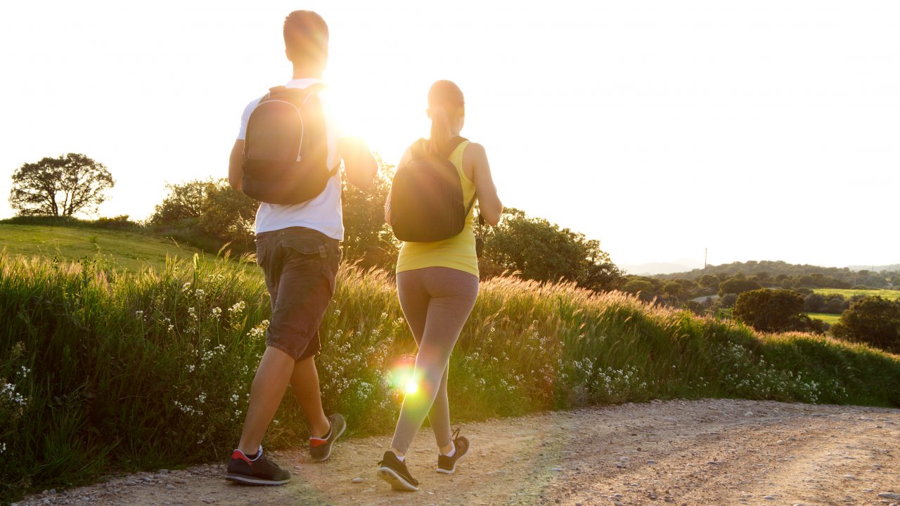 Trekking in Toscana - Portrait of Happy Young couple on the field in spring
